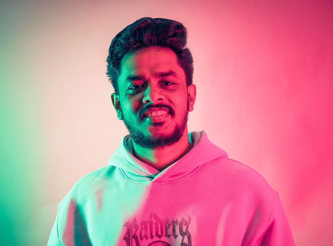 Student wearing a hoodie, smiling at the camera.