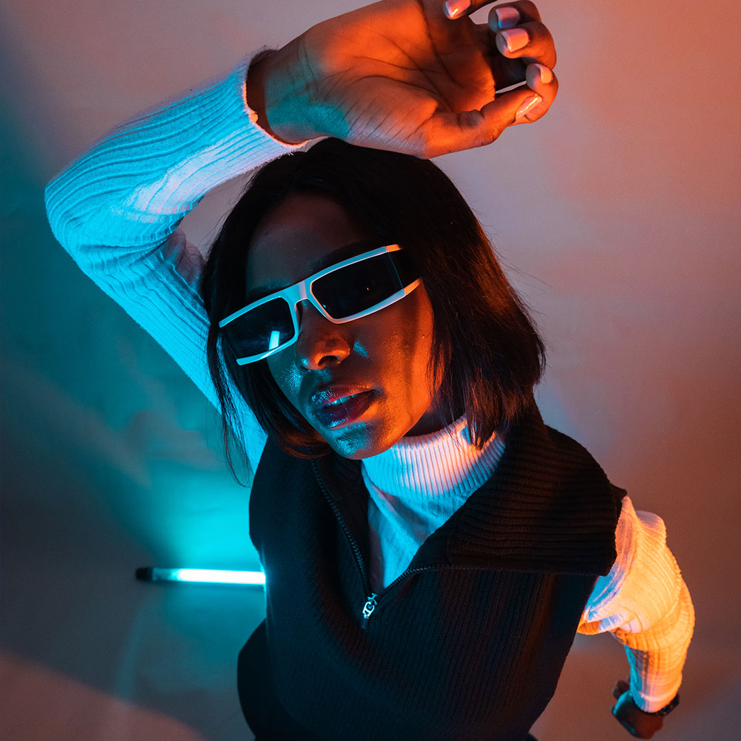An overhead shot of a student dancing around neon lights
