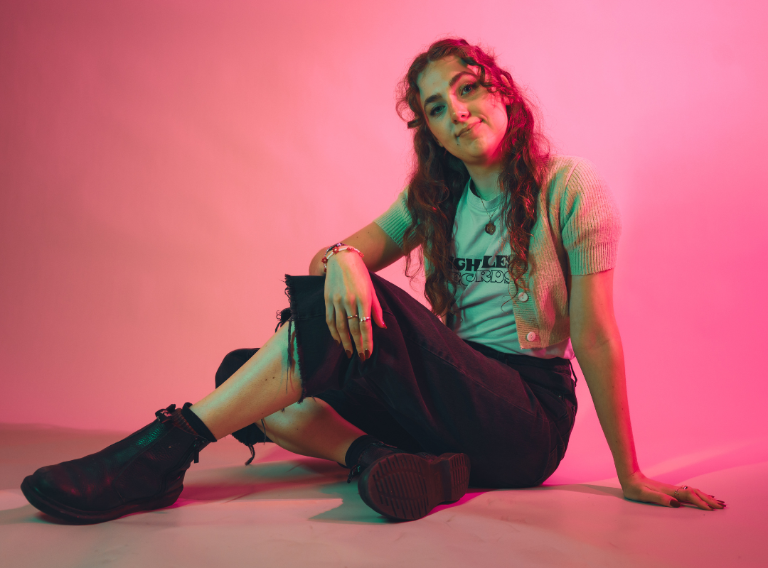 Molly, Hallam SU President 2025-26, sat on the floor with her legs crossed, looking relaxed and smiling.