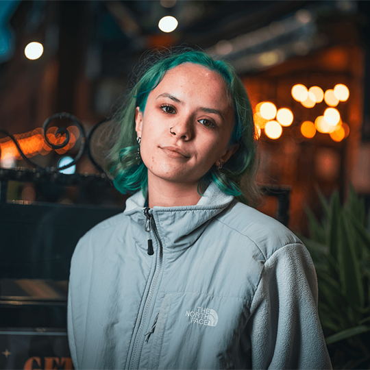 Person with green hair looking towards the camera