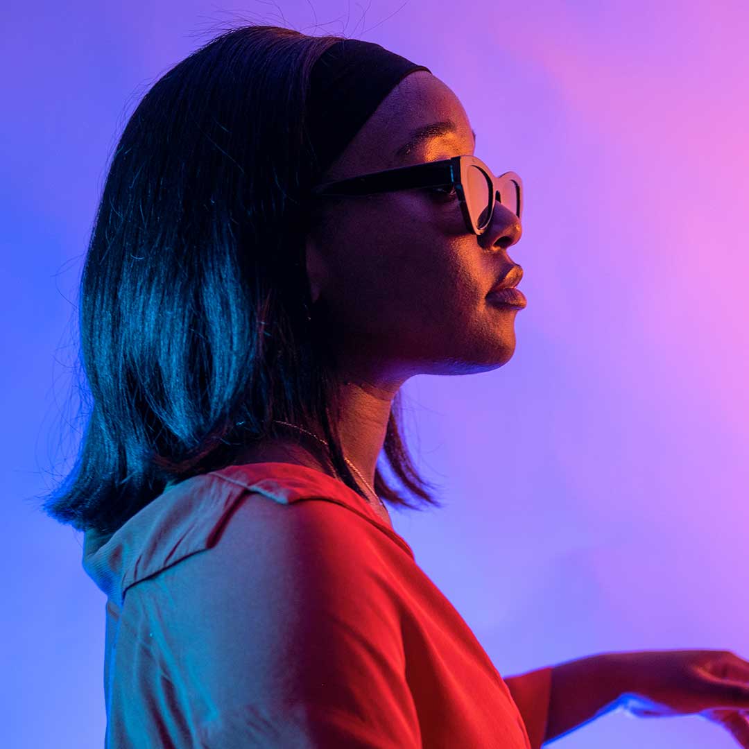 A student wearing sunglasses and looking off to the side of the camera