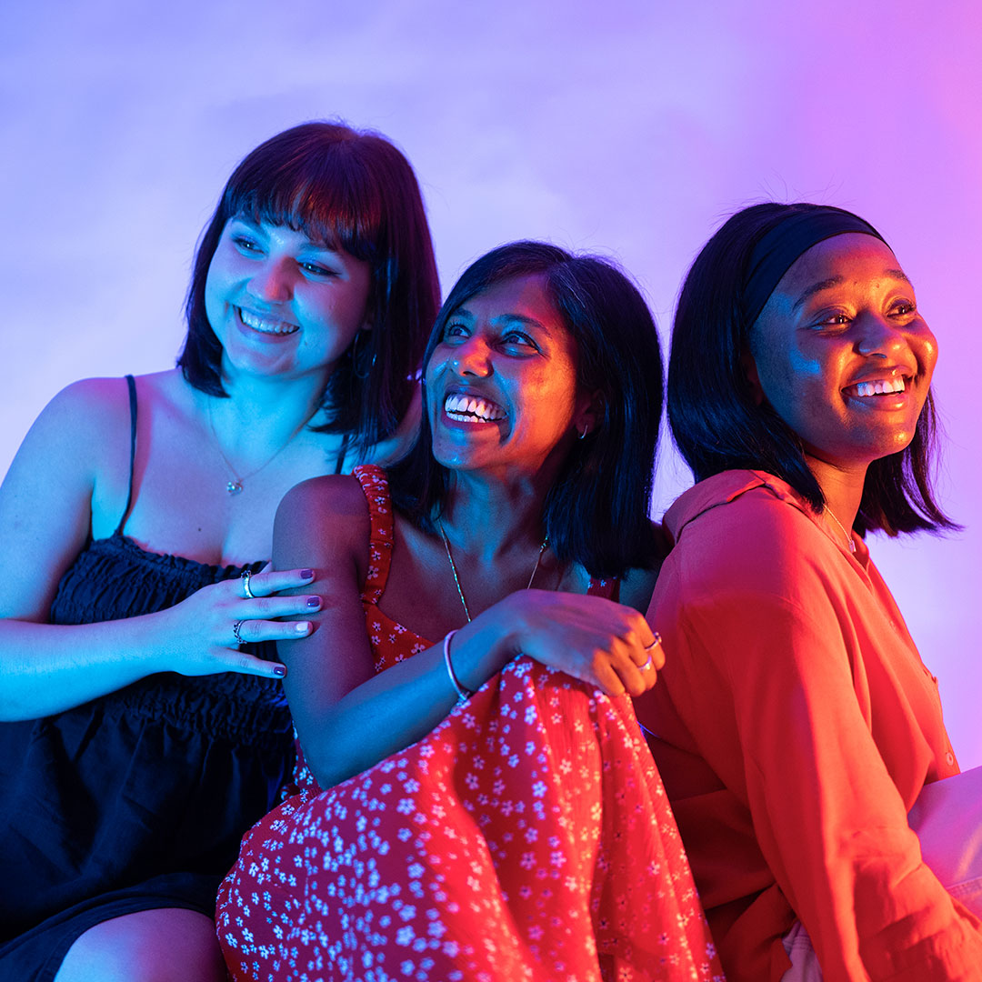 Three students sat on the floor laughing