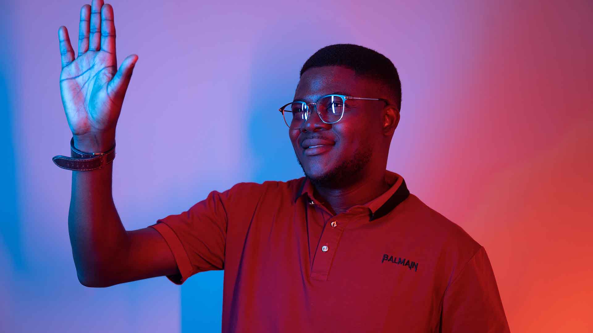 A Black student waving off to the side of the camera