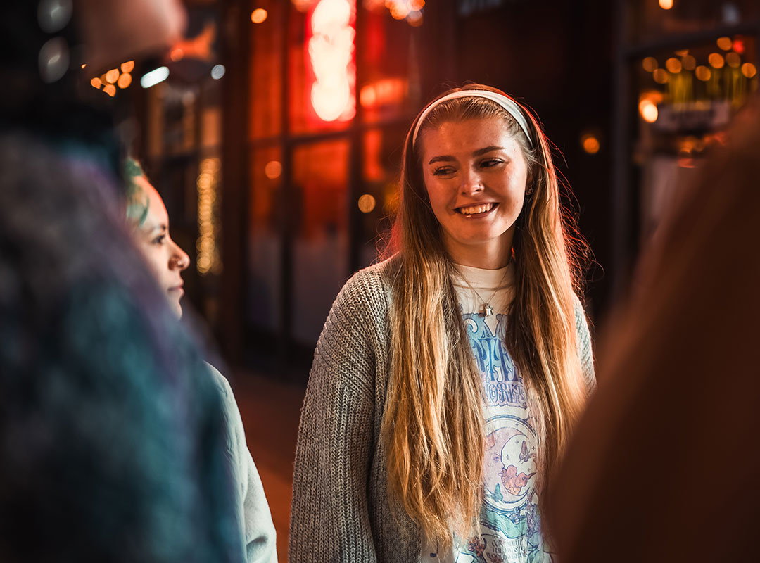 Student smiling at another student in a group