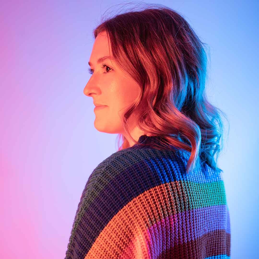 A student wearing a knitted sweater with large stripes of colour