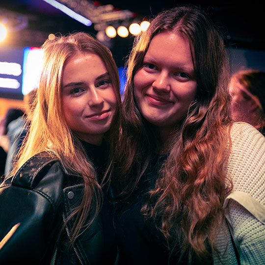 Two friends stood smiling together.